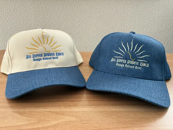 Two Big Dipper Sunrise Ranch hats with an embroidered sunrise logo