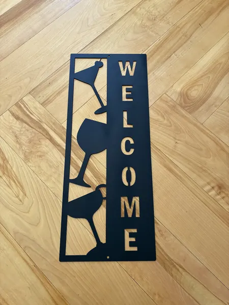 Black vertical steel WELCOME sign with cocktail and wine glass cutouts